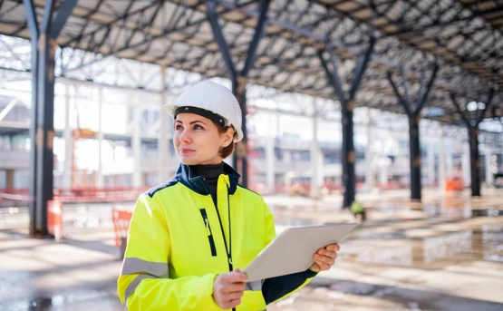 smiling construction worker looking at tablet