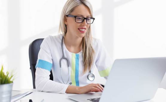 a medical professional looking at her laptop