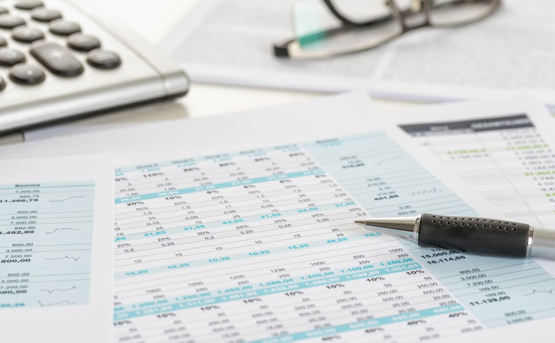 Financial paperwork on a table with a calculator 