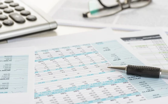 Financial paperwork on a table with a calculator 