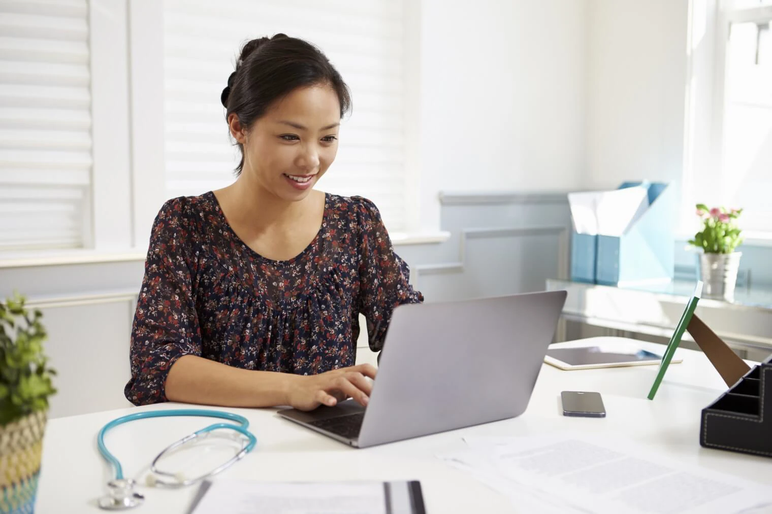 Women working on laptop with Stethescope on the desk