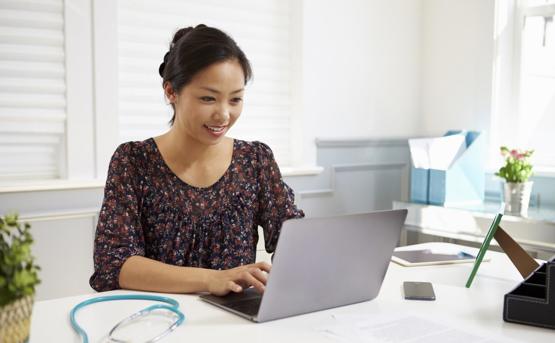 Women working on laptop with Stethescope on the desk