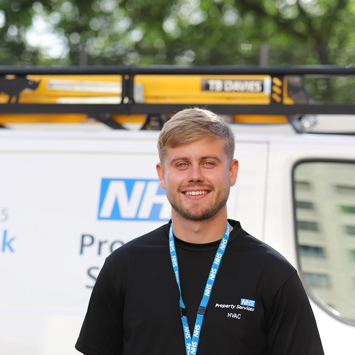 NHSPS HVAC engineer standing in front of NHSPS van