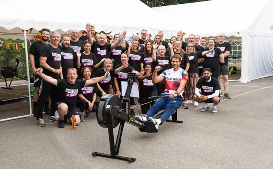 Group of NHSPS colleagues wearing Young Lives vs Cancer tshirts with a GB rowing champion for a rowing challenge