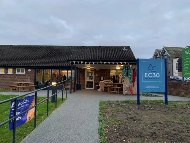 Front of EC30 with large blue sign saying 'EC30' and bunting at the front door
